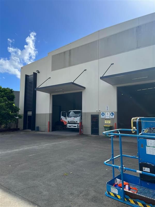 A large white building with a truck parked in front of it