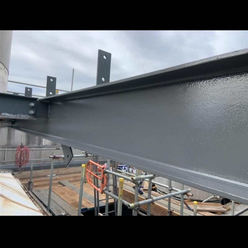 A large metal structure is being built on top of a wooden platform.