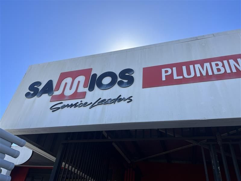 A white sign that says samos plumbing on it