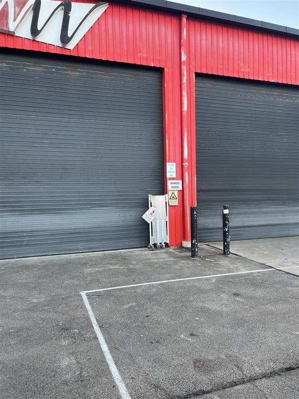 A red building with a parking lot in front of it