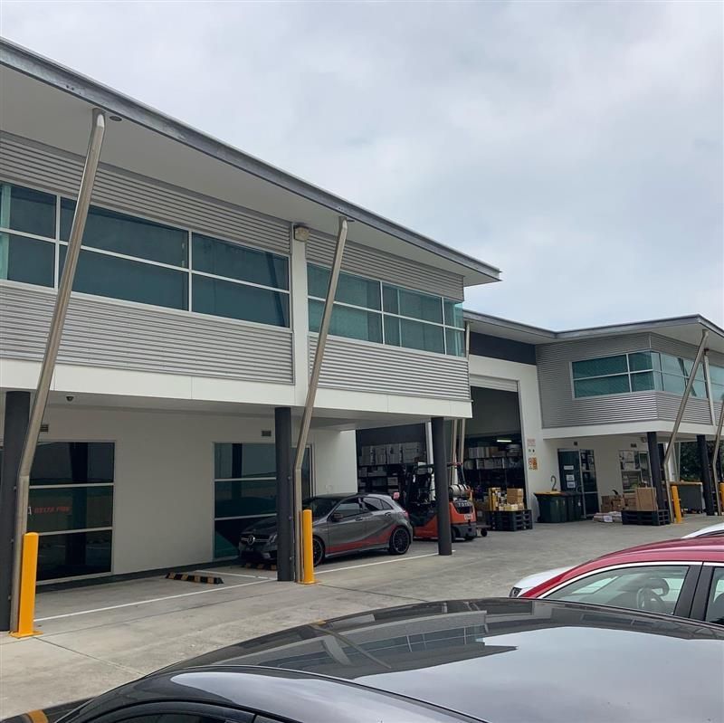 A large building with a lot of windows and cars parked in front of it.