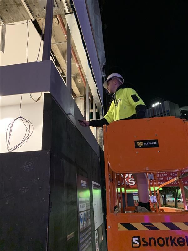 A man is working on a building on a ssnorkel lift