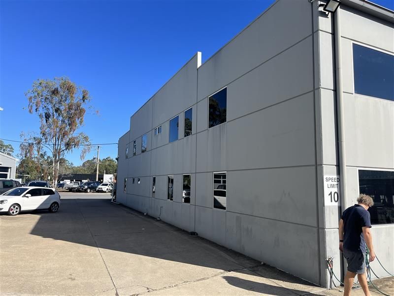 A man is standing in front of a large building.