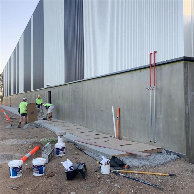 A group of construction workers are working on the side of a building.