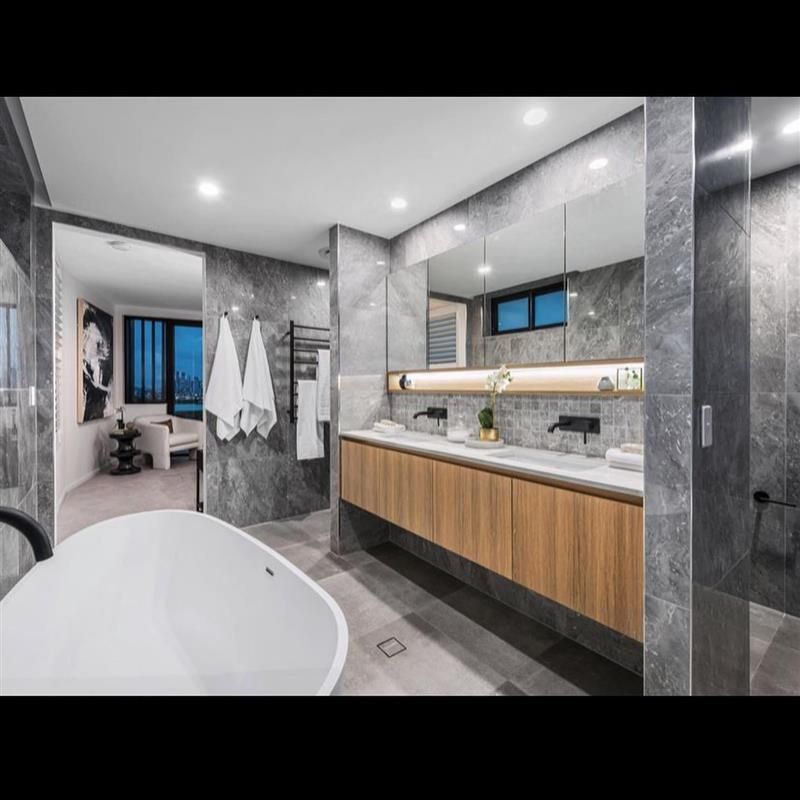 A bathroom with two sinks , a bathtub and a large mirror.