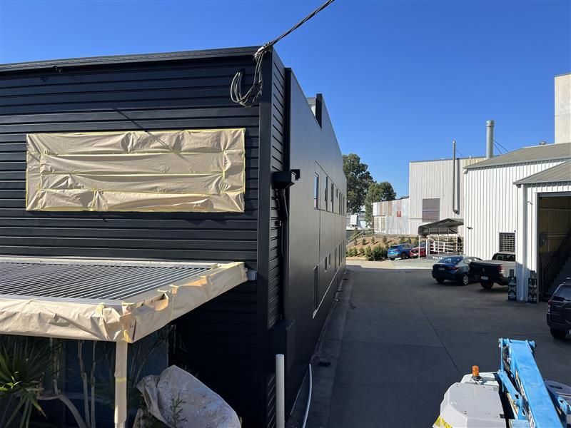 A black building with a white sign on the side of it.