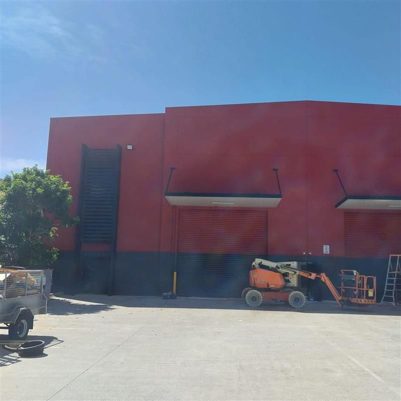 A large red building with a ladder in front of it