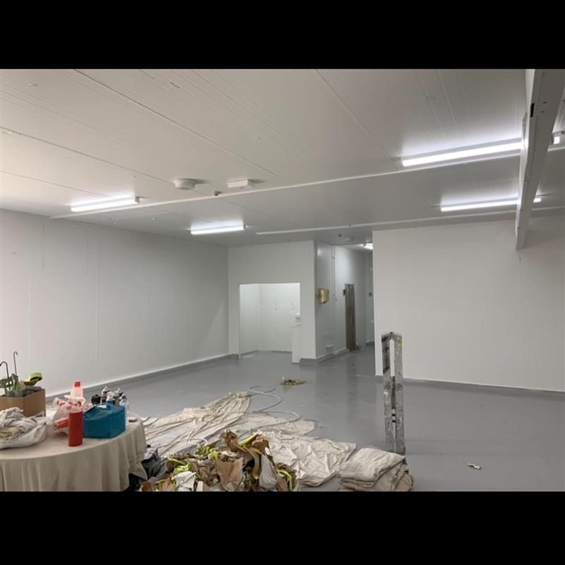 A large room with white walls and a table in the middle of it.