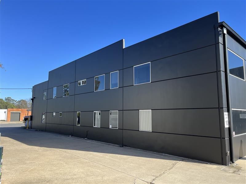 A large building with a lot of windows and a blue sky in the background