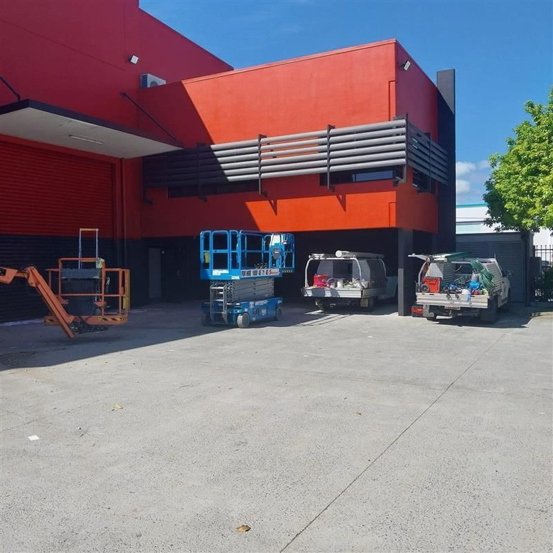 A red building with a lot of vehicles parked in front of it