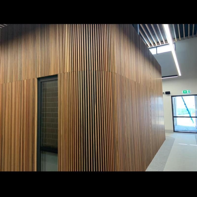 A hallway with a wooden wall and a window.
