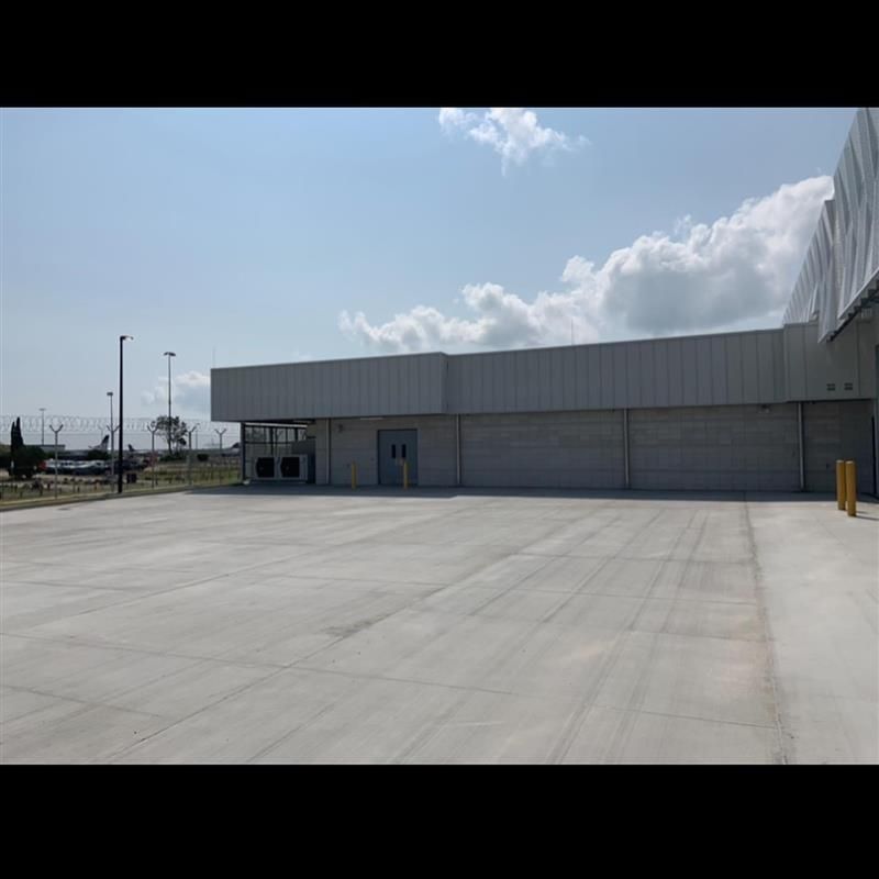 A large white building with a concrete driveway in front of it.
