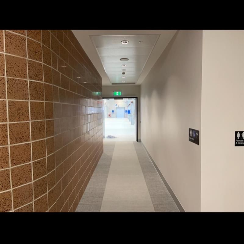 A long hallway with a toilet sign on the wall