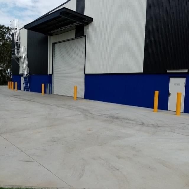 A building with blue and white walls and yellow poles