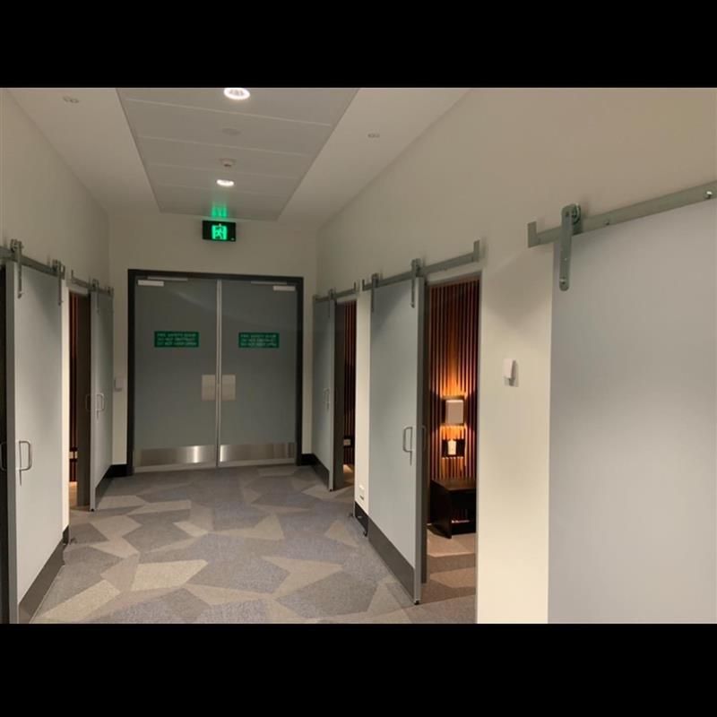 A hallway with sliding barn doors and a green exit sign