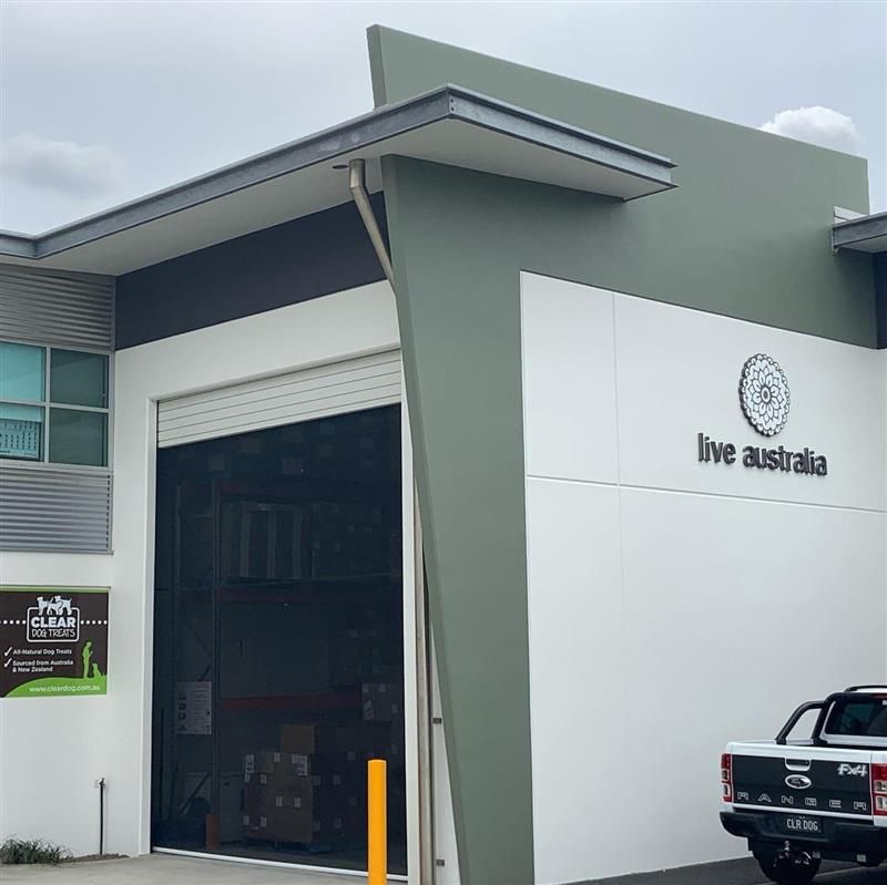 A truck is parked in front of a building that says live australia
