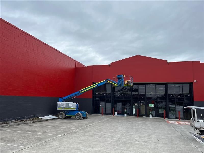 A large red building with a blue crane in front of it.