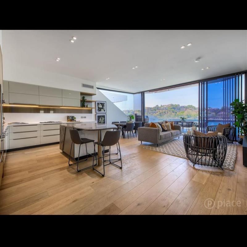 A living room with a couch and chairs and a kitchen