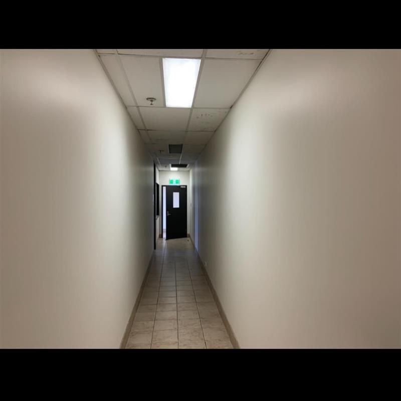 A long hallway with a door at the end of it.