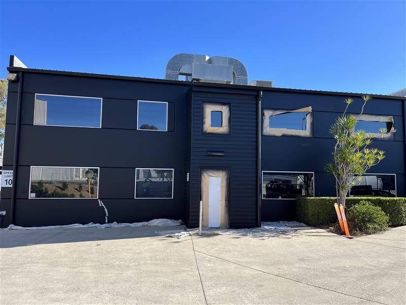 A large black building with a lot of windows and a door.