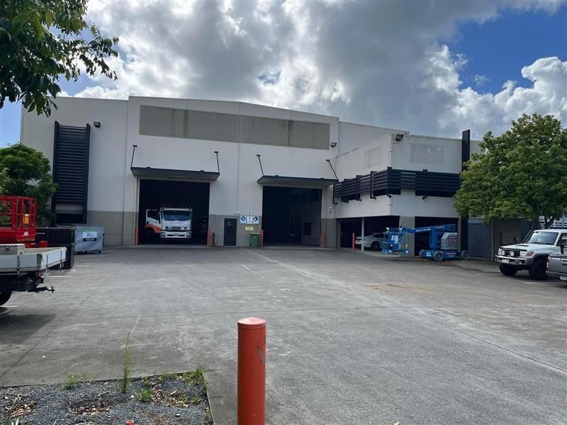 A large white building with a lot of cars parked in front of it.