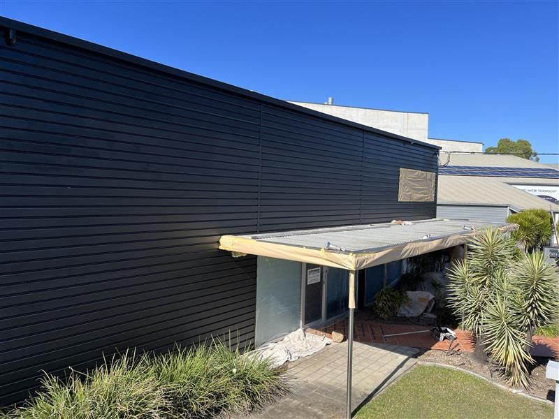 A black building with a canopy on the side of it.