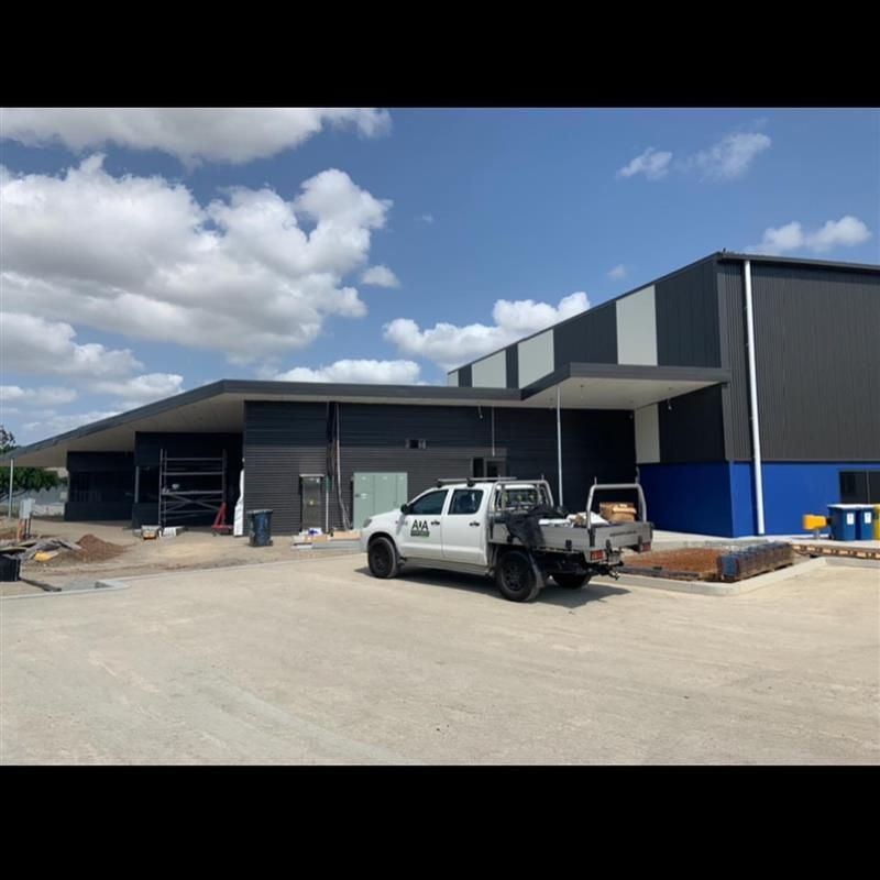 A white truck is parked in front of a building under construction.