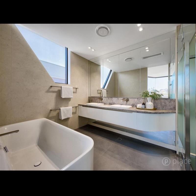 A bathroom with a tub , sink and mirror