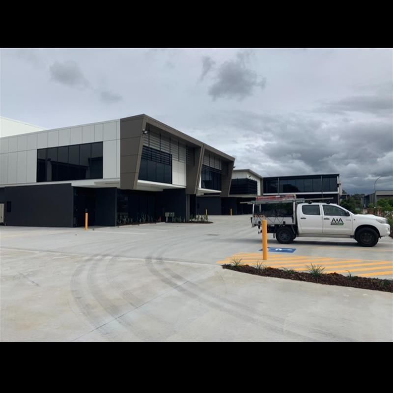 A white truck is parked in front of a large building
