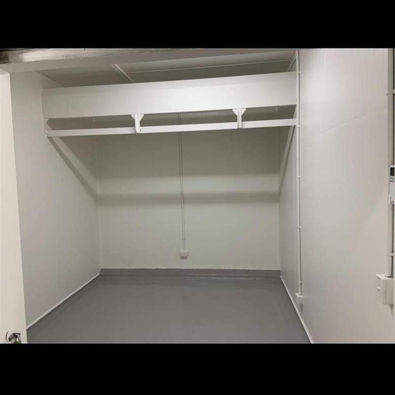 An empty room with a gray floor and white walls.