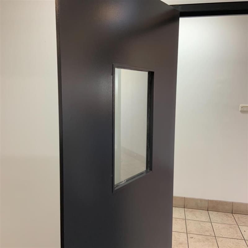 A black door with a small window in the middle of it.