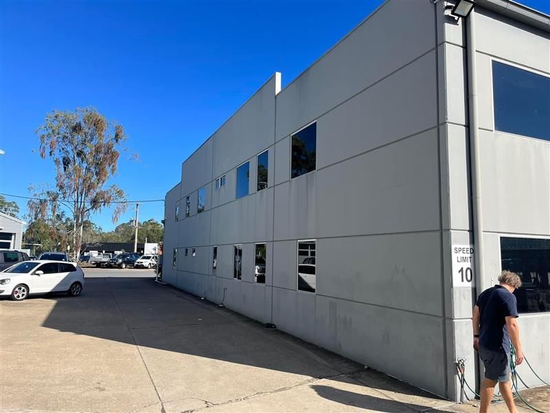 A man is standing in front of a large building.