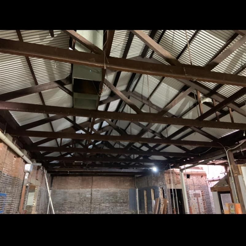 A room with a wooden ceiling and a brick wall