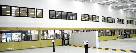 A warehouse with a lot of windows and a yellow barrier.