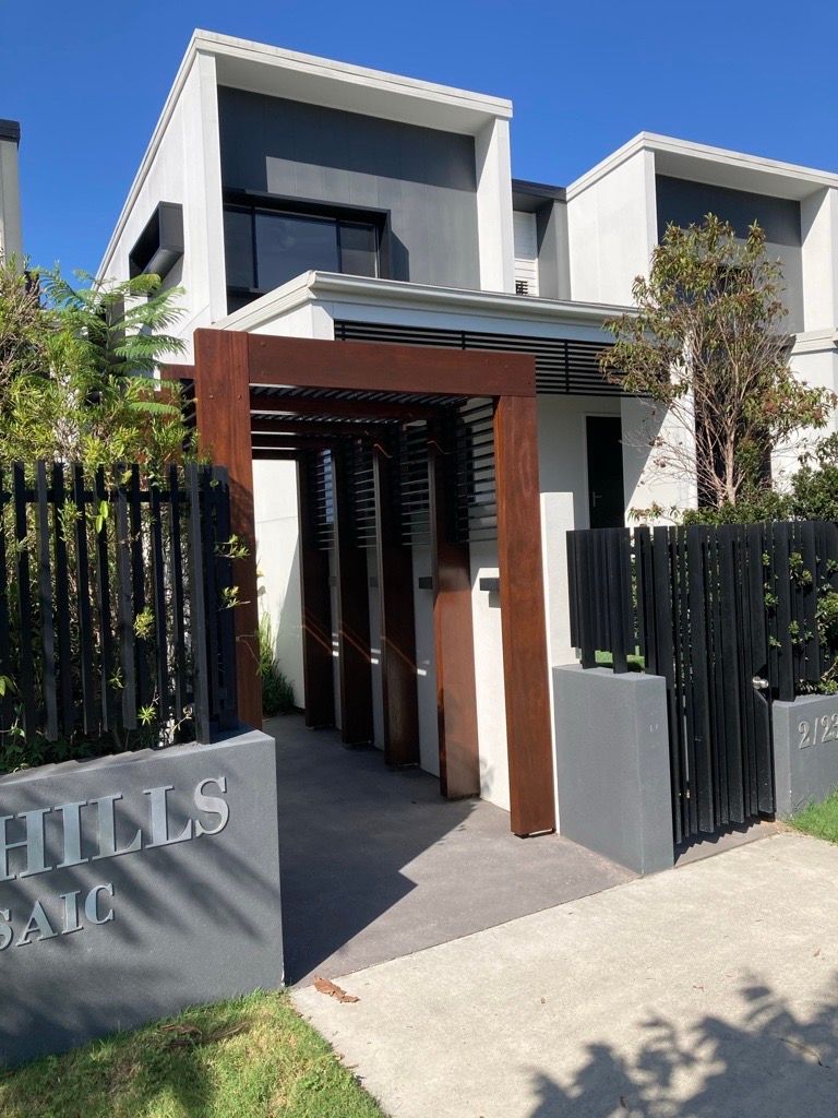A modern house with a fence and a sign that says hills ave.