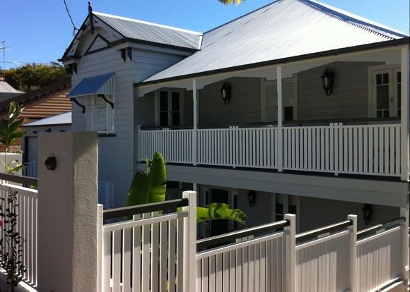 A white house with a porch and a white railing