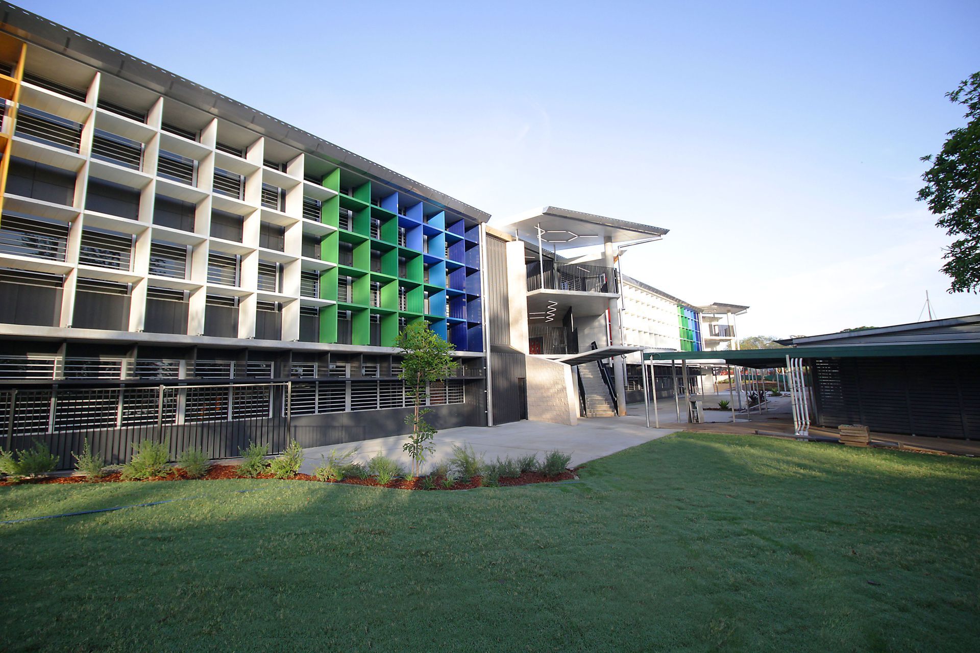 A large building with a lot of windows and a lawn in front of it