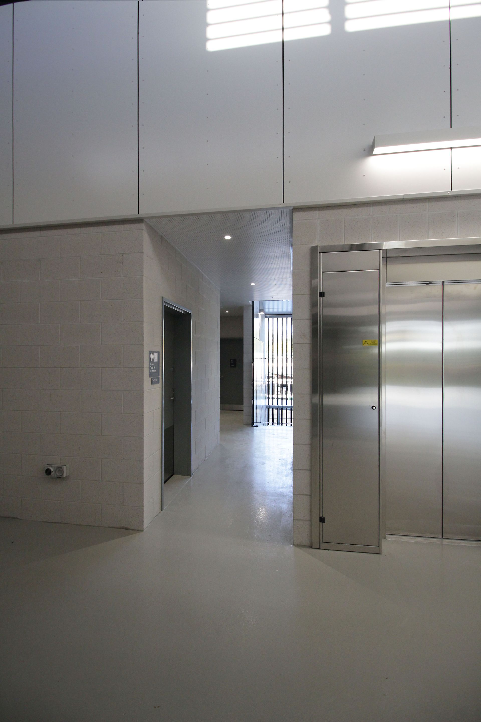 A hallway in a building with a stainless steel door