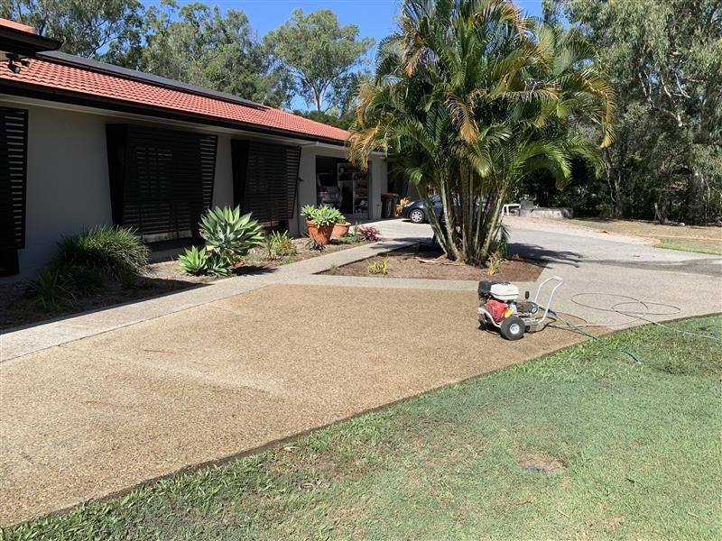 A lawn mower is sitting in front of a house.