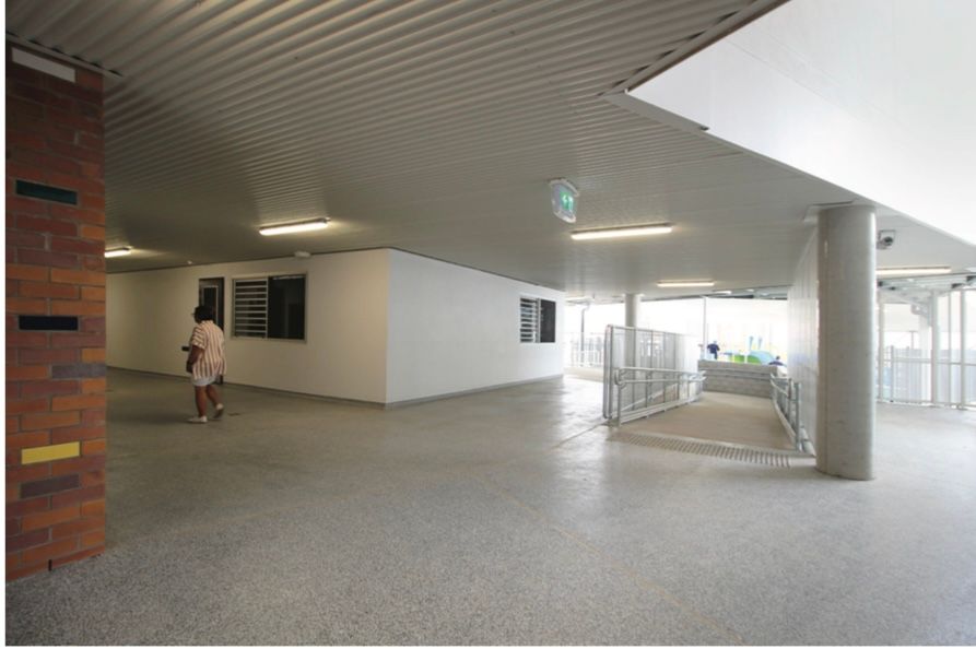 A woman is walking down a hallway in a building.