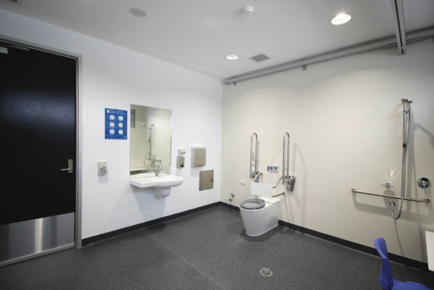 A bathroom with a toilet , sink and mirror
