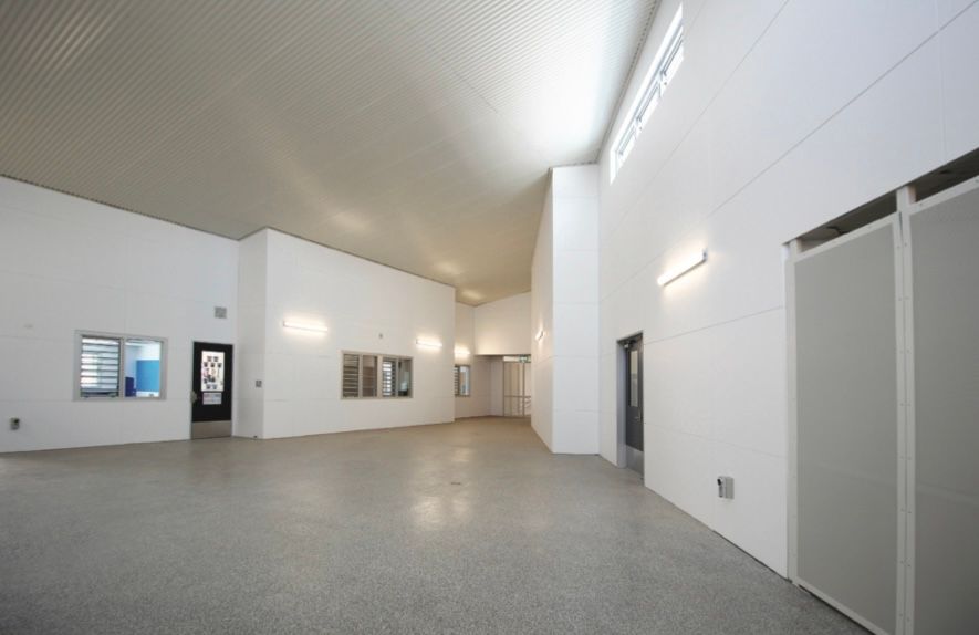 A large empty room with white walls and a gray floor