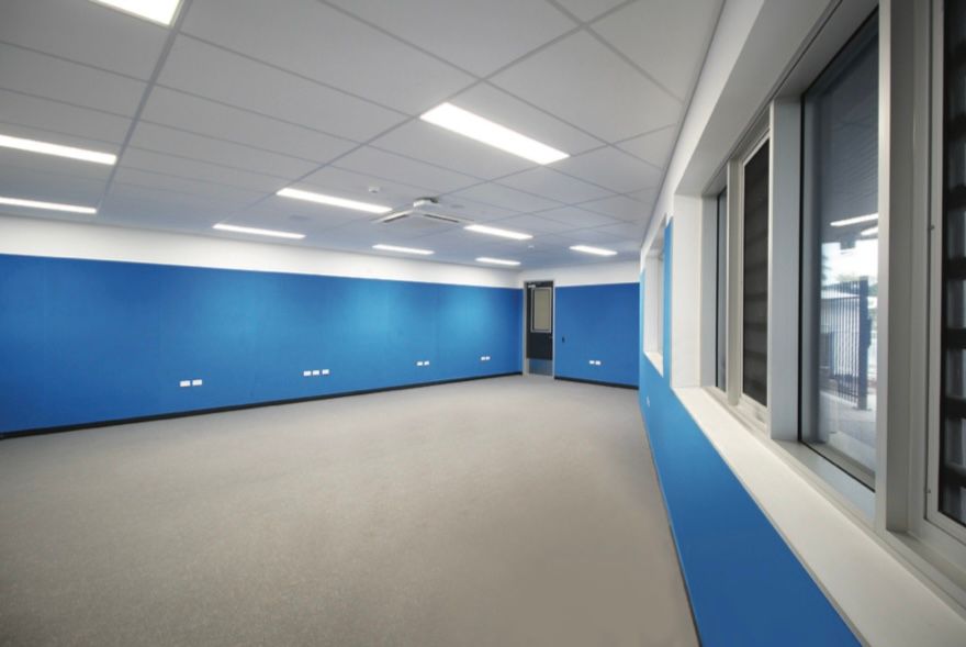 An empty room with blue walls and windows