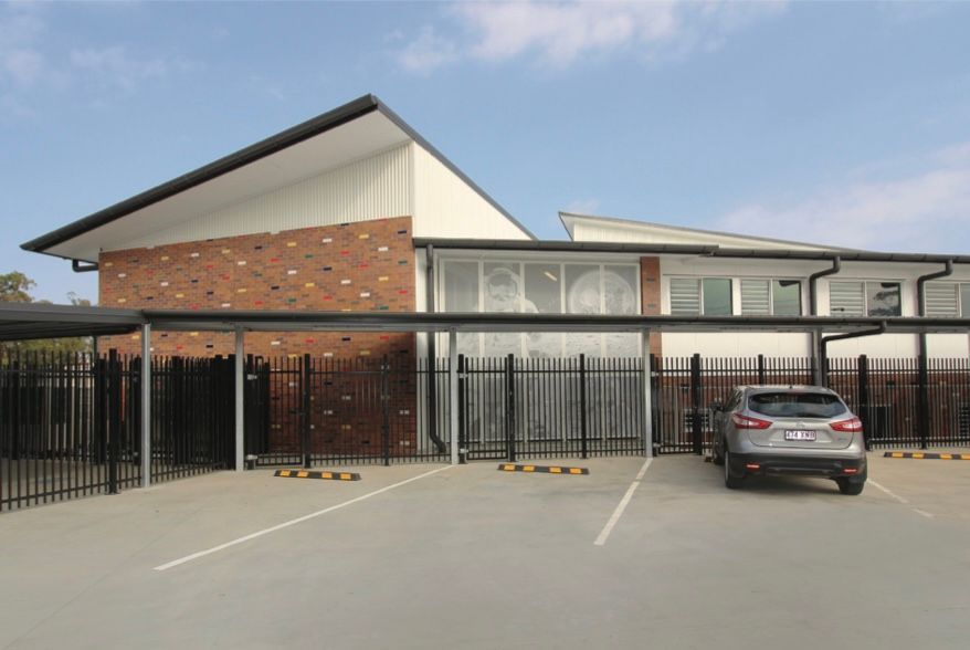 A car is parked in a parking lot in front of a building.