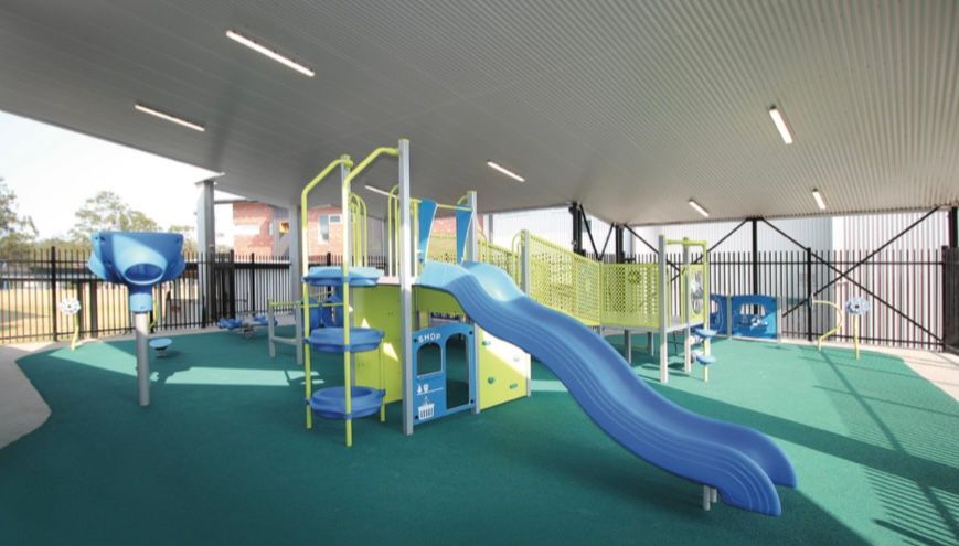 A blue and yellow playground with a slide and stairs.