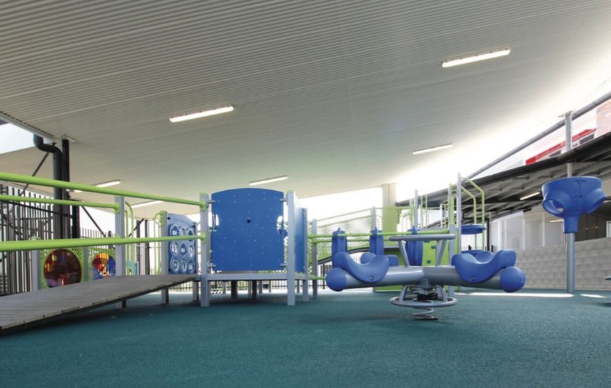 A playground with a blue seesaw and a ramp