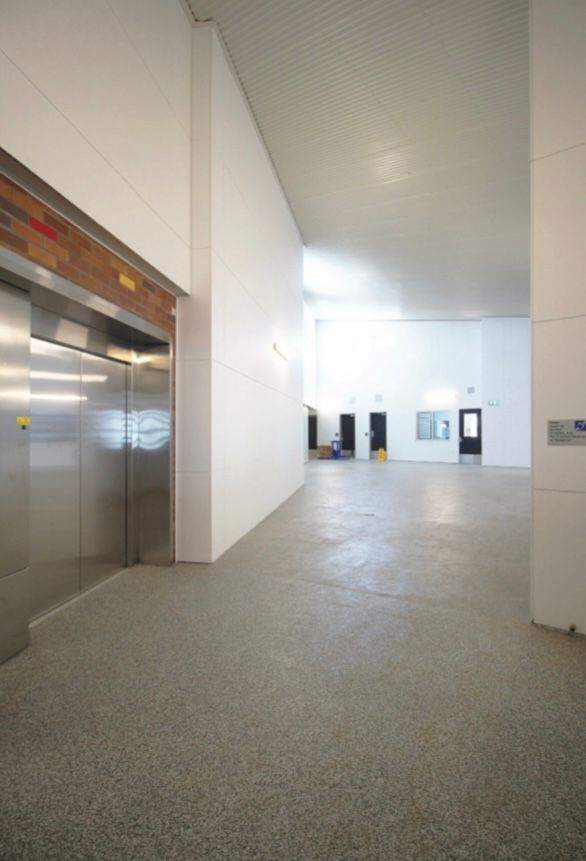 There is an elevator in the middle of the hallway.