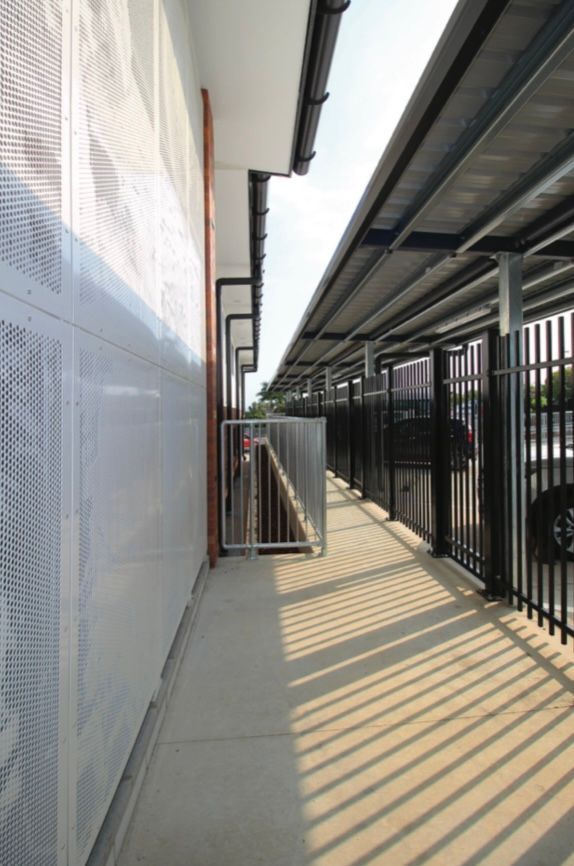 A long walkway between two buildings with a fence
