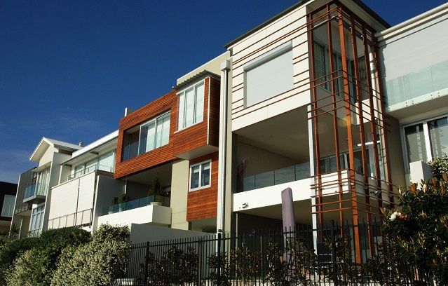 A row of apartment buildings with a blue sky in the background