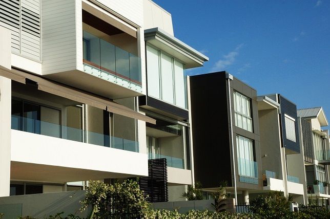 A row of houses with balconies and a blue sky in the background